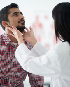 Doctor examining male patient's neck