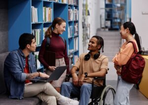 Diverse,Group,Of,Students,With,Young,Man,In,Wheelchair,Chatting