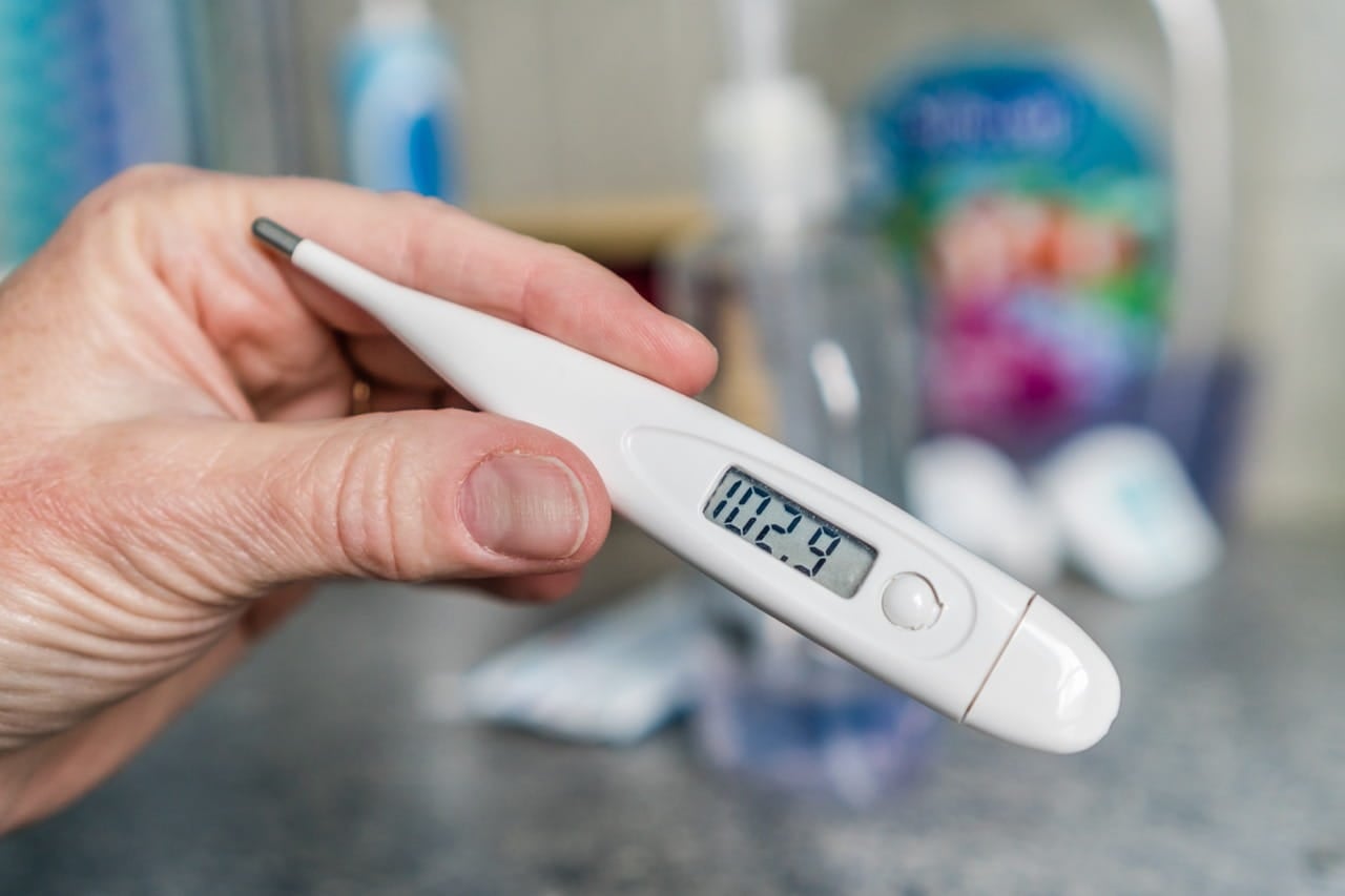 Close up of a hand holding a thermometer